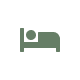 Green icon of a person lying in a bed, viewed from the side, set against a white circular background.